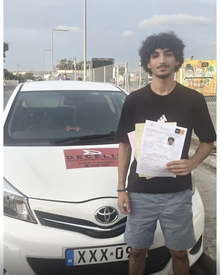 A new driver on pass day, in front of a Decelis Toyota Yaris
